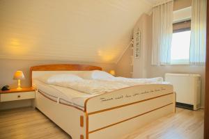 un letto bianco in una stanza con una finestra di Haus Moin Moin a Grömitz