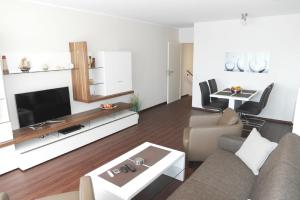 een woonkamer met een bank en een tv bij Haus Belvedere App 13 Stellpl 70 in Grömitz