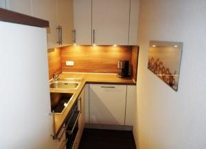 een kleine keuken met een wastafel en een aanrecht bij Haus Belvedere App 13 Stellpl 70 in Grömitz