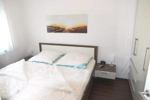 een wit bed met 2 kussens in een slaapkamer bij Haus Belvedere App 13 Stellpl 70 in Grömitz