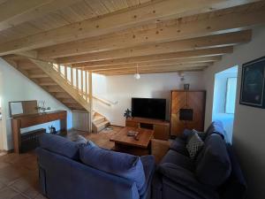 a living room with a couch and a tv at Quinta do Carvalho Cerquinho in Louriceiras de Baixo