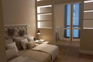 ein Schlafzimmer mit einem Bett, einer Lampe und einem Fenster in der Unterkunft Smarthouse Corso Peschiera in Turin