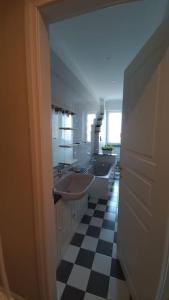 ein Badezimmer mit zwei Waschbecken und einem karierten Boden in der Unterkunft Smarthouse Corso Peschiera in Turin