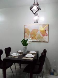 a black dining room table with chairs and a potted plant at Camella Manor Majorca 7A in Bacolod