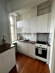 uma cozinha com armários brancos e um forno com placa de fogão em Studio Mansku em Helsinque