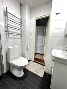 a white bathroom with a toilet and a sink at Studio Mansku in Helsinki