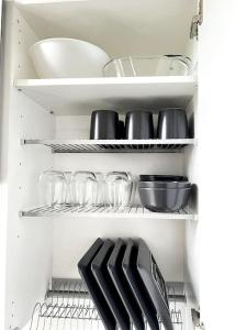 einen weißen Kühlschrank mit Geschirr und Küchenutensilien in der Unterkunft Studio Mansku in Helsinki