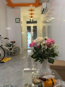 eine Vase mit Blumen auf einem Tisch in einem Zimmer in der Unterkunft Homestay Hoa Anh in Haiphong