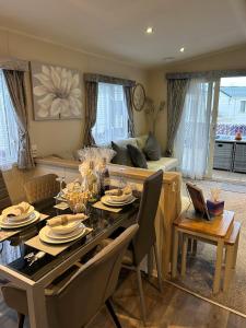 a living room with a table and a couch at Beautiful Spacious Holiday Home - Romney Sands in New Romney