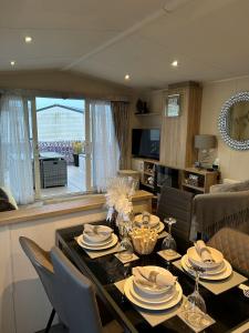 a living room with a dining room table with chairs at Beautiful Spacious Holiday Home - Romney Sands in New Romney