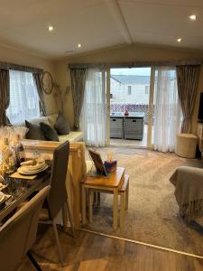 a living room with a couch and a table at Beautiful Spacious Holiday Home - Romney Sands in New Romney