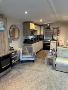 a living room with a couch and a kitchen at Beautiful Spacious Holiday Home - Romney Sands in New Romney