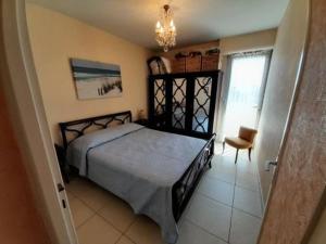 um quarto com uma cama e um lustre em Appartement Saint-Gilles-Croix-de-Vie, 3 pièces, 5 personnes - FR-1-324-548 em Saint-Gilles-Croix-de-Vie