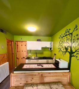 eine grüne Küche mit einem Baumbild an der Wand in der Unterkunft Il Nido Dell'Aquila-Piancavallo in Piancavallo