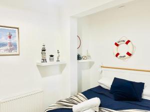 a white bedroom with a bed and a red lighthouse at Seafront Apartment in Portsmouth