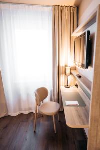 Zimmer mit einem Schreibtisch, einem Stuhl und einem Fenster in der Unterkunft City Park Hotel in Frankfurt (Oder)
