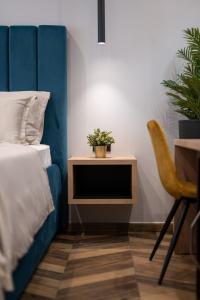 Un dormitorio con una cama y una mesa con una planta. en West Coast Deluxe Rooms - Vacation Rental, en Split