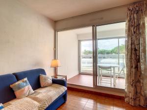 salon z kanapą i dużym oknem w obiekcie Appartement T2 Climatisé avec Loggia et Parking à Carnon - FR-1-715-40 w mieście Mauguio