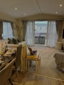 a living room with a couch and a table at Beautiful Spacious Holiday Home - Romney Sands in New Romney
