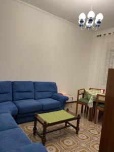 da Lilia in Salute&Bellezza في مونفالكوني: غرفة معيشة مع أريكة زرقاء وطاولة