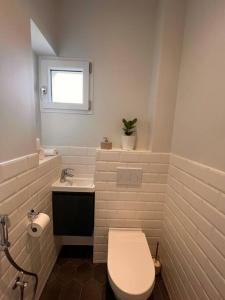biała łazienka z toaletą i umywalką w obiekcie appartement 15min de Paris w mieście Drancy +5 zdjęć