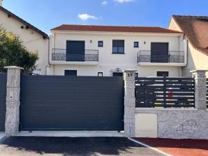Czarna brama przed domem w obiekcie appartement 15min de Paris w mieście Drancy