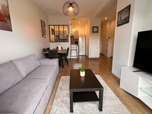 salon z kanapą i stołem w obiekcie appartement 15min de Paris w mieście Drancy