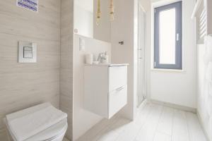 a white bathroom with a toilet and a sink at Giewont View Apartamenty z widokiem - Butikowe & Sauna - Grunwaldzka Krupówki Centrum Zakopane by RentiloPL in Zakopane +156 photos