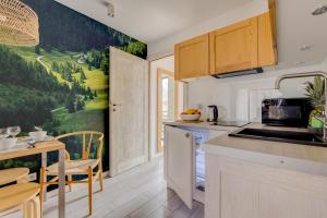a kitchen and dining room with a painting on the wall at Giewont View Apartamenty Butikowe & Sauna Grunwaldzka by RentiloPL in Zakopane