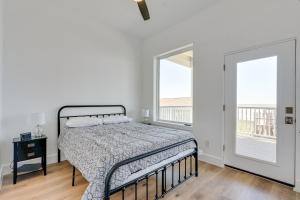 Un dormitorio con una cama y dos ventanas. en Modern Galveston Vacation Rental Steps to Beach!, en Galveston