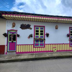 uma casa colorida com portas coloridas e uma cerca em Hostal Casa Madrigal em Filandia