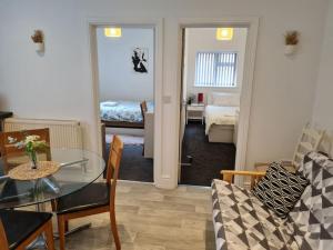 a living room with a table and a room with a bedroom at The Lawrence apartment in Bristol