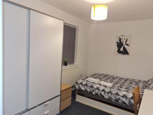 a bedroom with a bed and a dresser and a window at The Lawrence apartment in Bristol