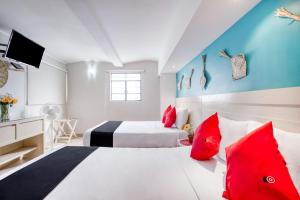 um quarto com uma cama grande e almofadas vermelhas em Hotel El Andariego em Oaxaca de Juárez