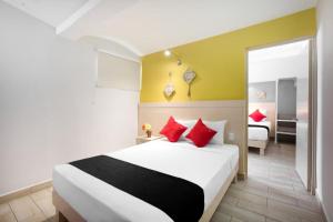 a bedroom with a large bed with red pillows at Hotel El Andariego in Oaxaca City
