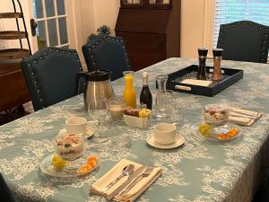 a table with a blue table cloth with food on it at Baker Street Bed and Breakfast in Eufaula