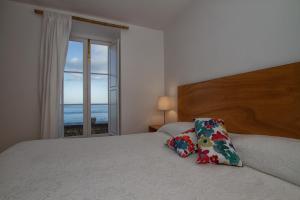 a bedroom with a bed with a view of the ocean at Casa do Lado in Povoação