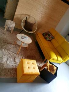 un soggiorno con divano giallo e tavolo di Linda House a Casais de São Mamede