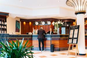 a man standing at the bar of a restaurant at City Park Hotel in Frankfurt Oder