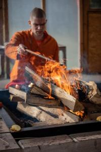 Ein Mann arbeitet an einem Stück Feuer. in der Unterkunft Hindu Monastery - Shree Peetha Nilaya Ashram in Springen