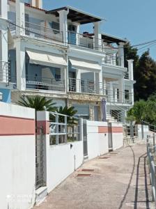 un edificio de apartamentos con vallas blancas y una acera en House Sofia Loutsa Prevezas, en Loutsa