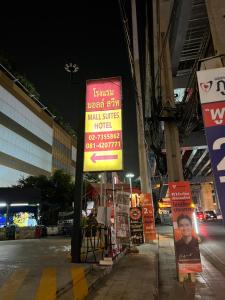 een bord aan de zijkant van een straat 's nachts bij Mall Suites Hotel in Bangkok