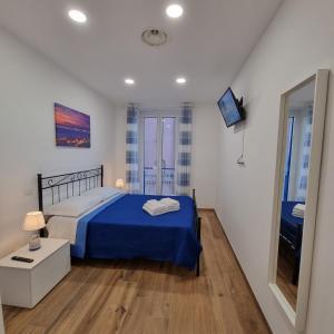 a bedroom with a blue bed and a mirror at Filoblu appartamento Formia in Formia