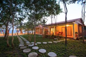 
a house that has some trees in the grass at Wild Beach Phu Quoc Resort in Phú Quốc
