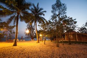 
a beach with palm trees and palm trees at Wild Beach Phu Quoc Resort in Phú Quốc
