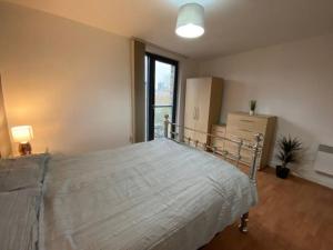 a bedroom with a large bed in a room with a window at Superb 1 Bedroom Serviced Apartment In City Centre in Birmingham