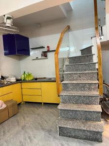 eine Treppe in einer Küche mit gelbem Tresen in der Unterkunft Homestay Hoa Anh in Haiphong