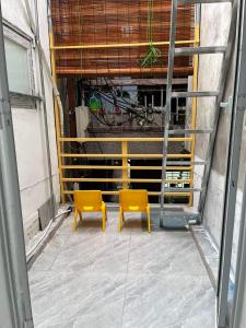 zwei gelbe Stühle in der Mitte eines Gebäudes in der Unterkunft Homestay Hoa Anh in Haiphong