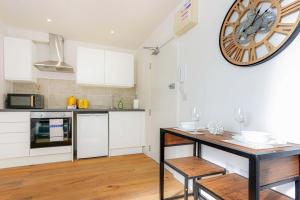 a kitchen with a table and a large clock on the wall at Central Buckingham Apartment #4 with Free Parking, Pool Table, Fast Wifi and Smart TV with Netflix by Yoko Property in Buckingham