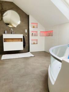 bagno con lavandino, vasca e specchio di Ferienhaus Ruhe Oase im Bayerischen Wald a Traitsching